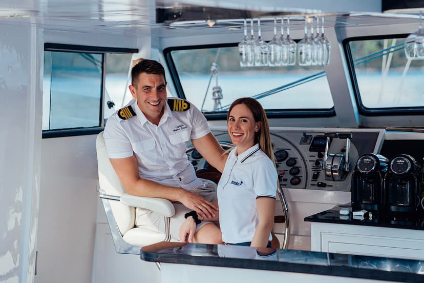 Captain and crew smiling in the bright white helm of a gulet boat.