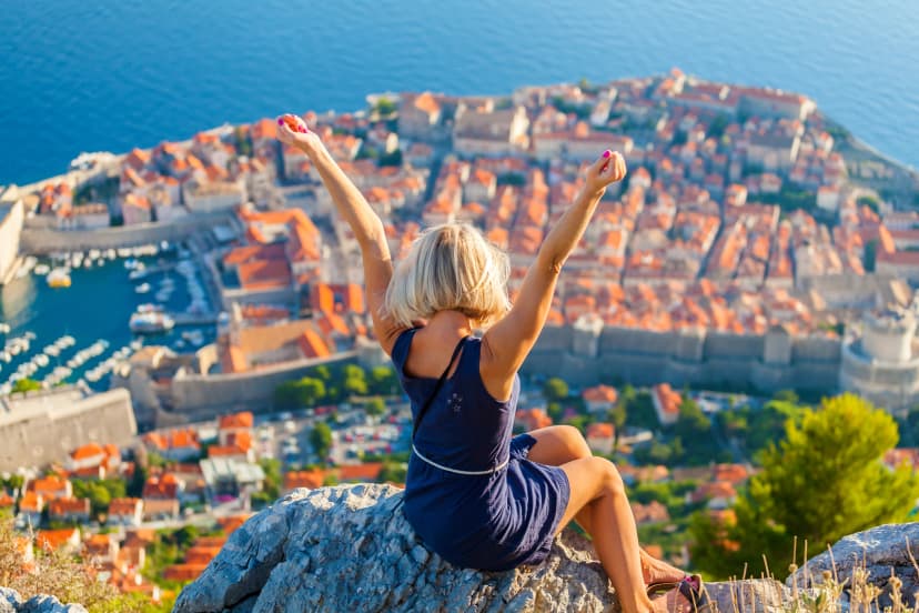 Young woman tourist looks to the old city of Dubrovnik.