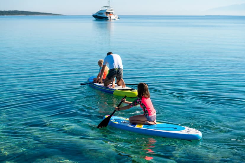 Happy Family on SUP stand up paddle on vacation.
