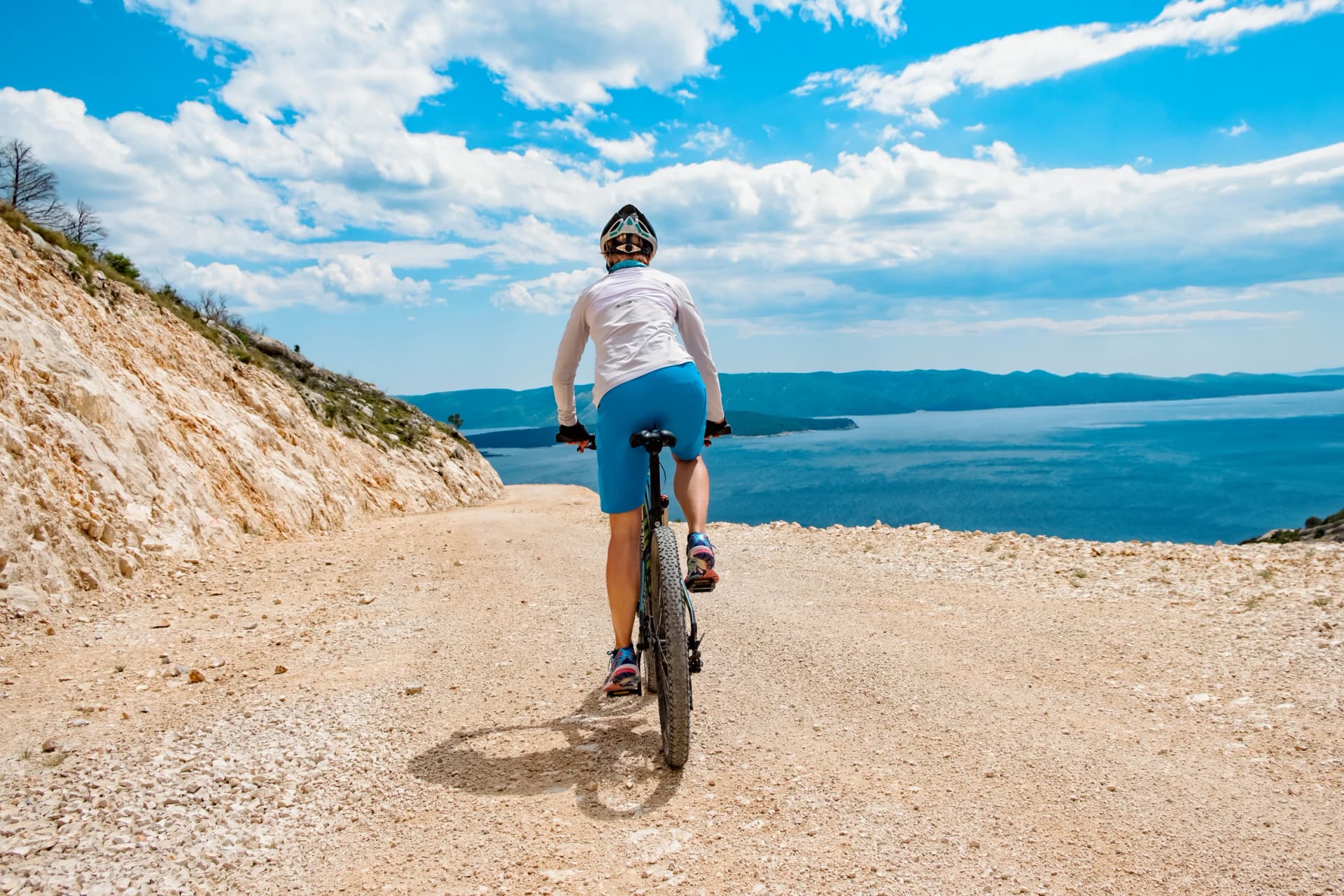 Woman biking coast of croatia