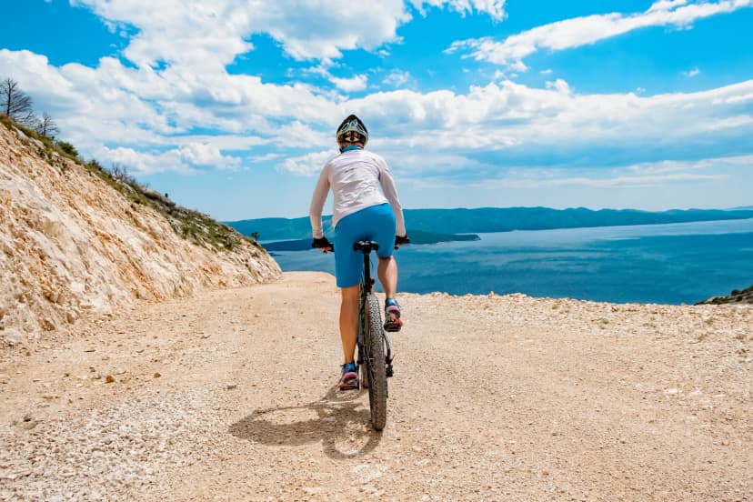 Woman biking coast of croatia