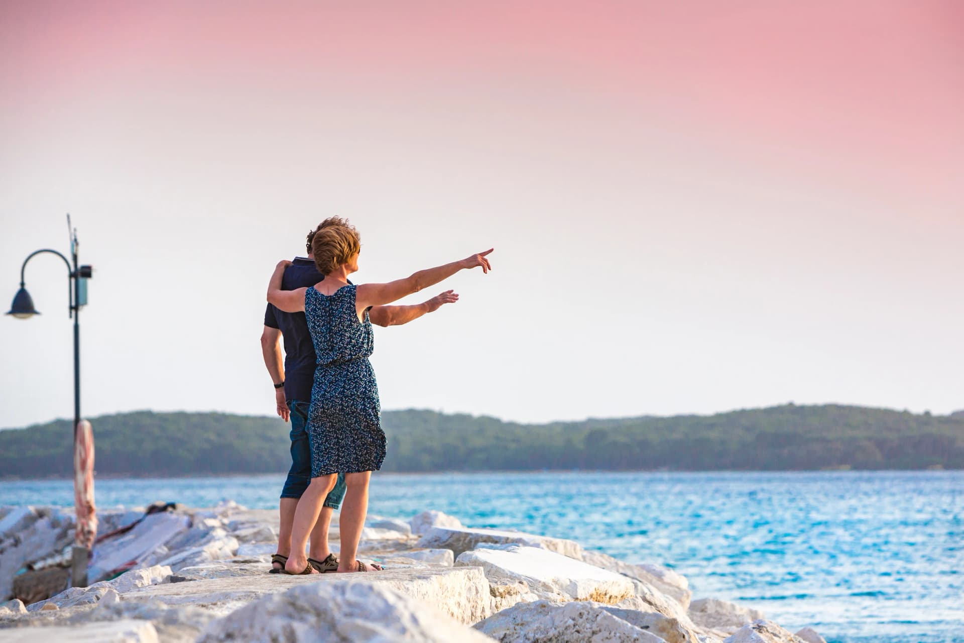 Croatia, Istria, couple enjoying sunset on the pier