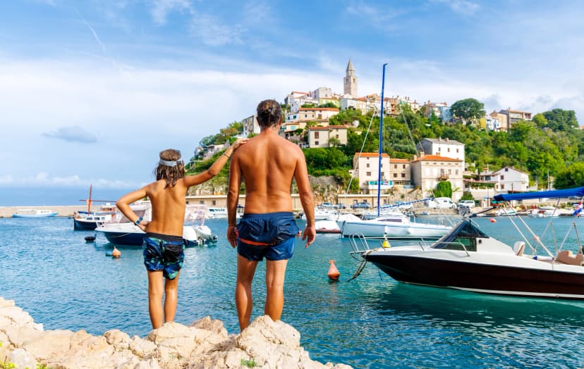 Family vacation in Croatia- father and son on the beach, adriatic sea, Vrbnik city