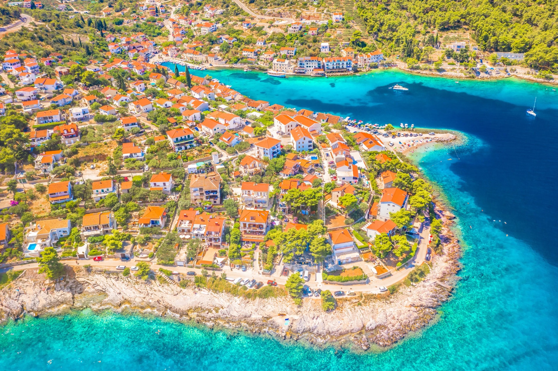 A breathtaking HDR aerial view of Stomorska on Solta Island, Croatia, showcasing its vibrant waterfront, and bustling marina filled with boats, capturing the lively charm of this coastal gem