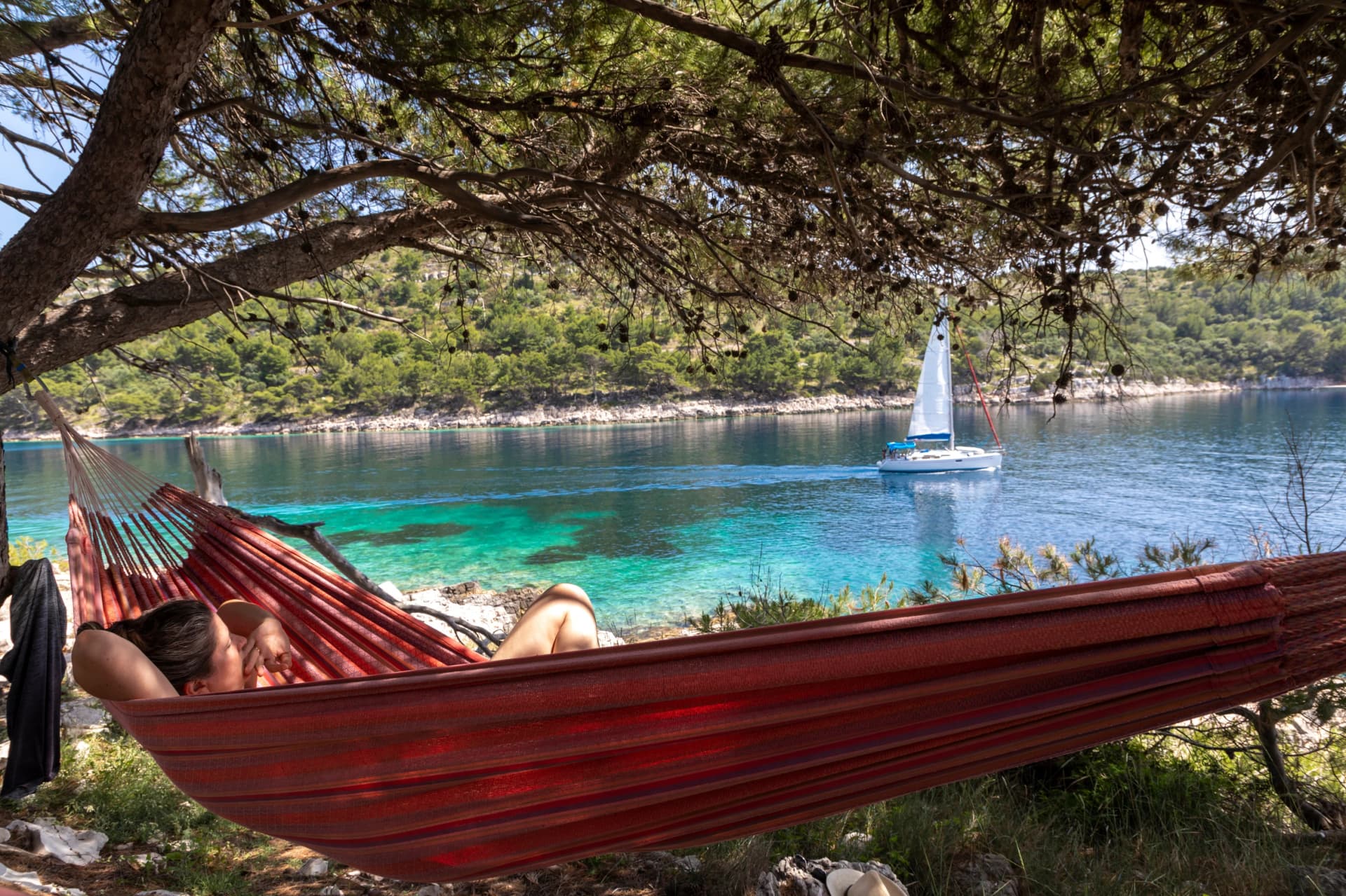 Woman relaxing in the hammock on a hot sunny day on the island lastovo, croatia
