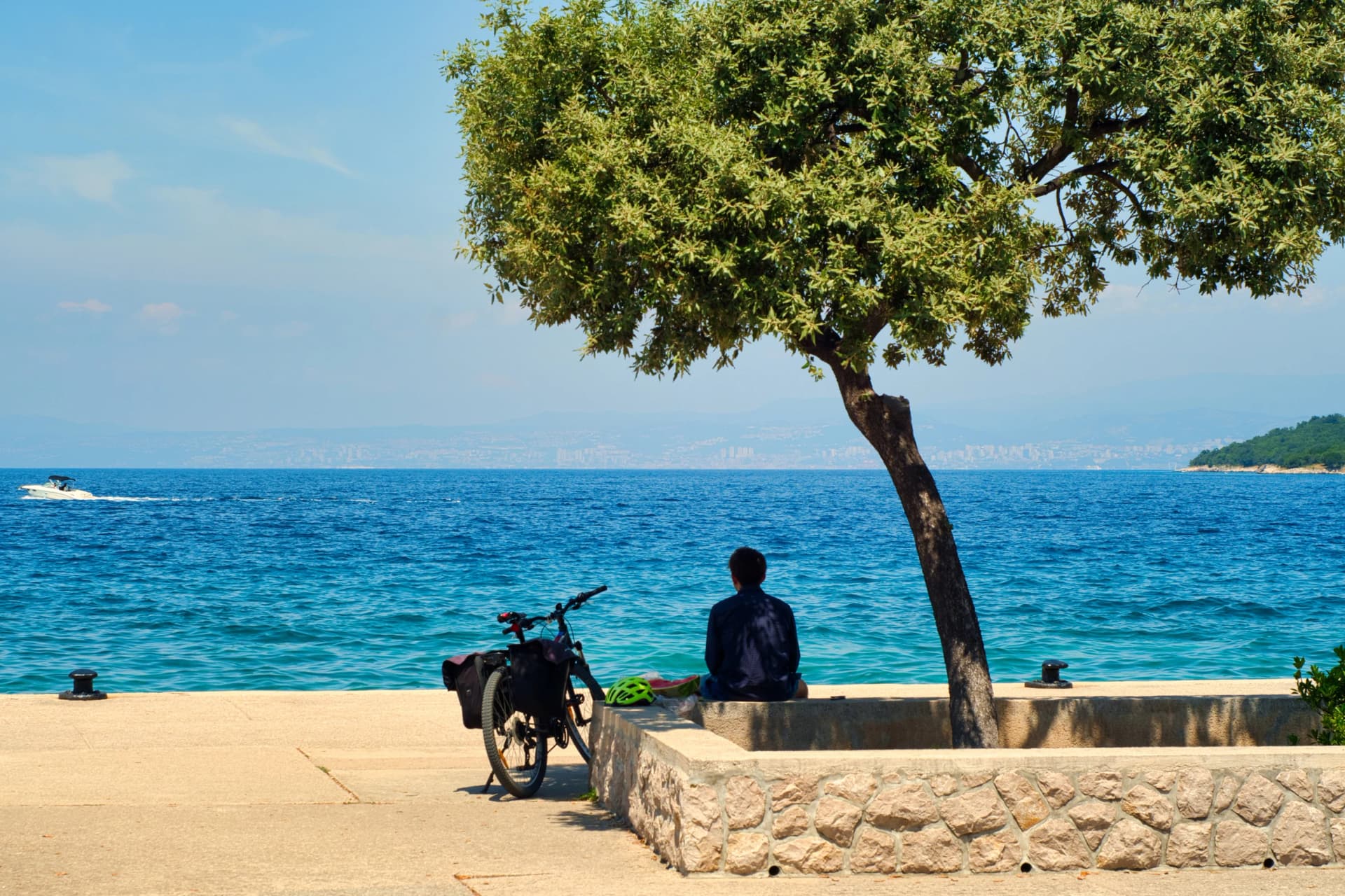 Sweet summer vacation dreams - lonely young man with bike watching the sea on Croatia island Krk