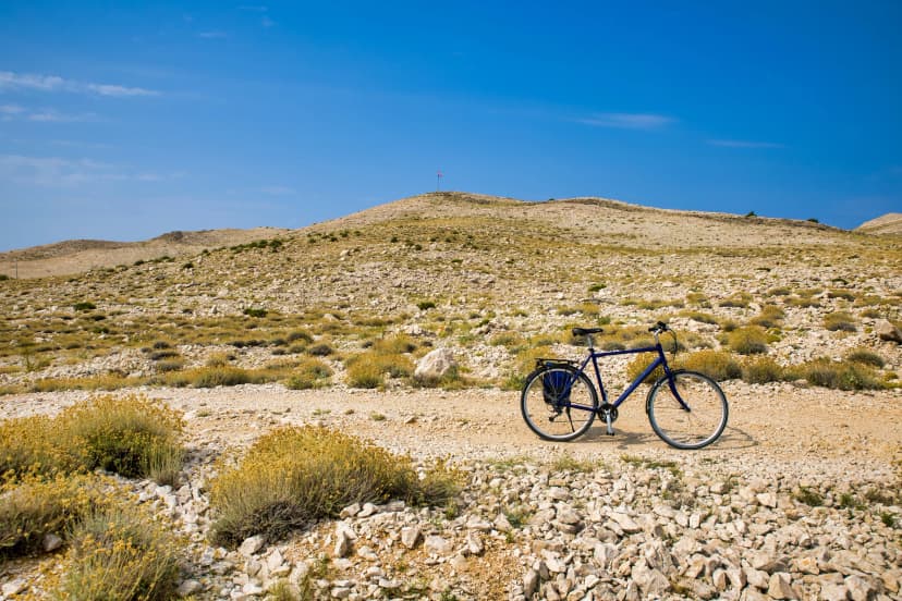 a lonely bicycle in front of a barren landscape in croatia on island pag.